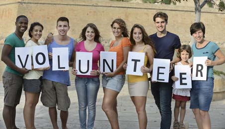 Young people standing with boards of volunteering