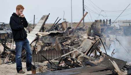 Gavin Byrne views damage in the Breezy Point area of Queens in New York on October 30, 2012 after fire destroyed about 80 homes as a result of Hurricane Sandy